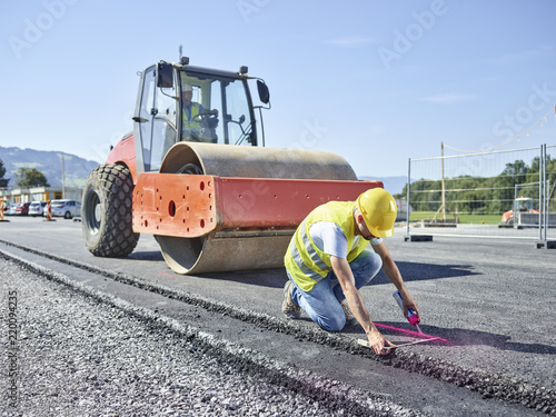 Worker marking roadside on construction site photo