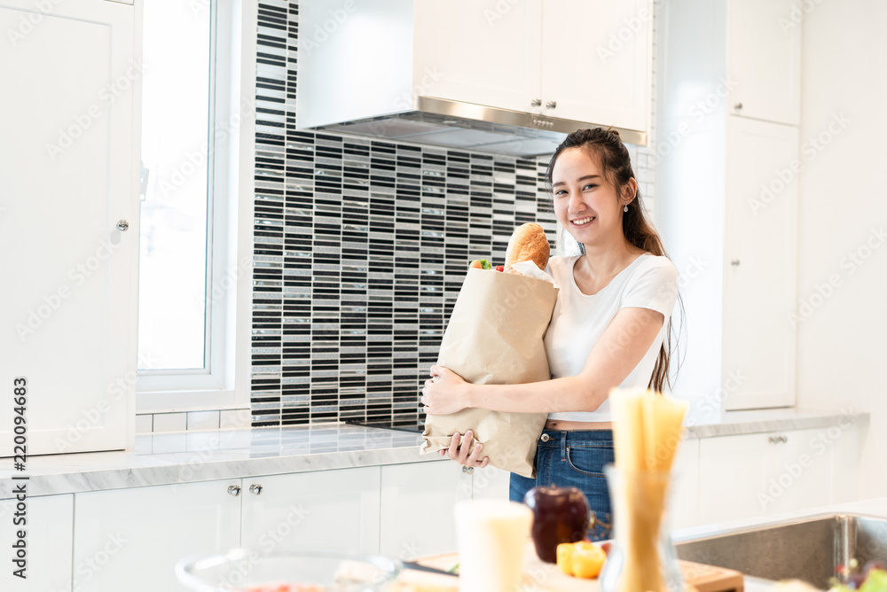 Asian beauty woman holding bag of ingredients for cooking after shopping at supermarket People and lifestyles concept. Food and meal. Happiness of single woman theme. Family and dinner party theme.