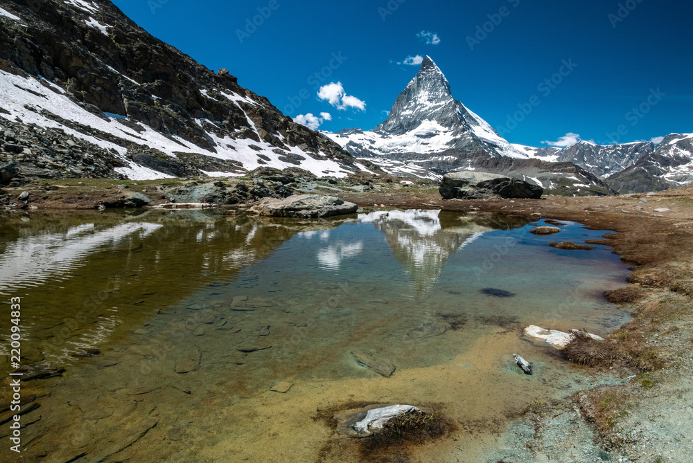 Obraz premium Scenic view of Matterhorn and its reflection on Riffelsee, an alpine lake of Riffelhorn in Zermatt, Switzerland.