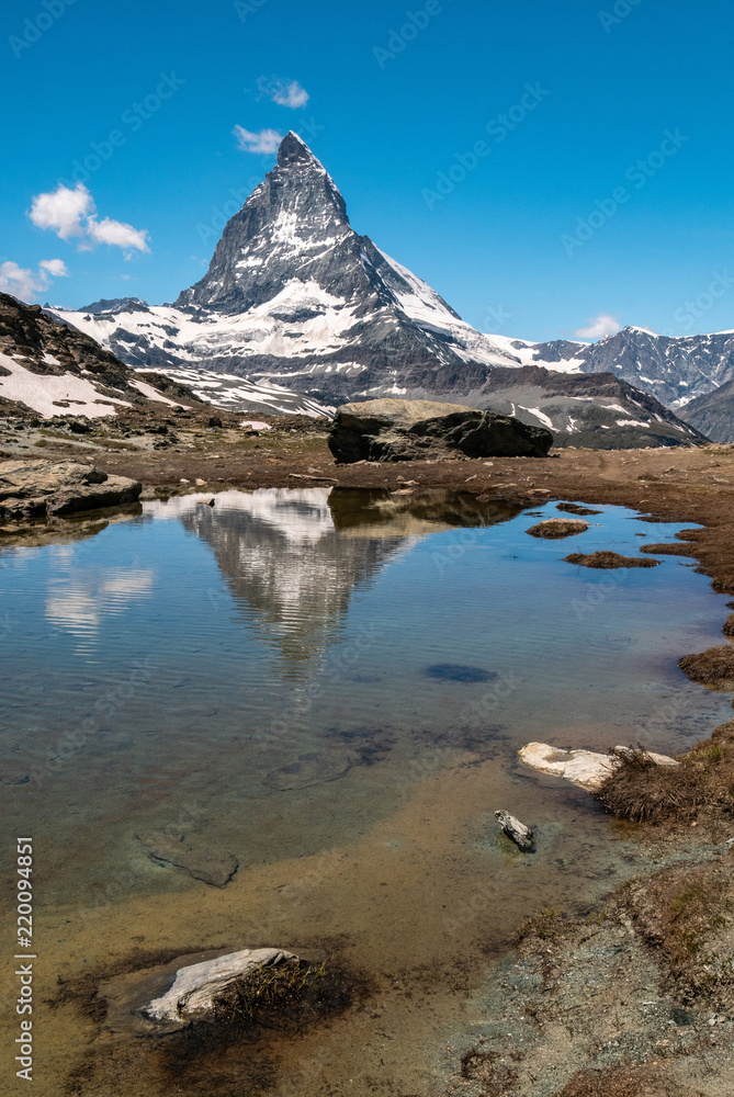 Obraz premium Scenic view of Matterhorn and its reflection on Riffelsee, an alpine lake of Riffelhorn in Zermatt, Switzerland.