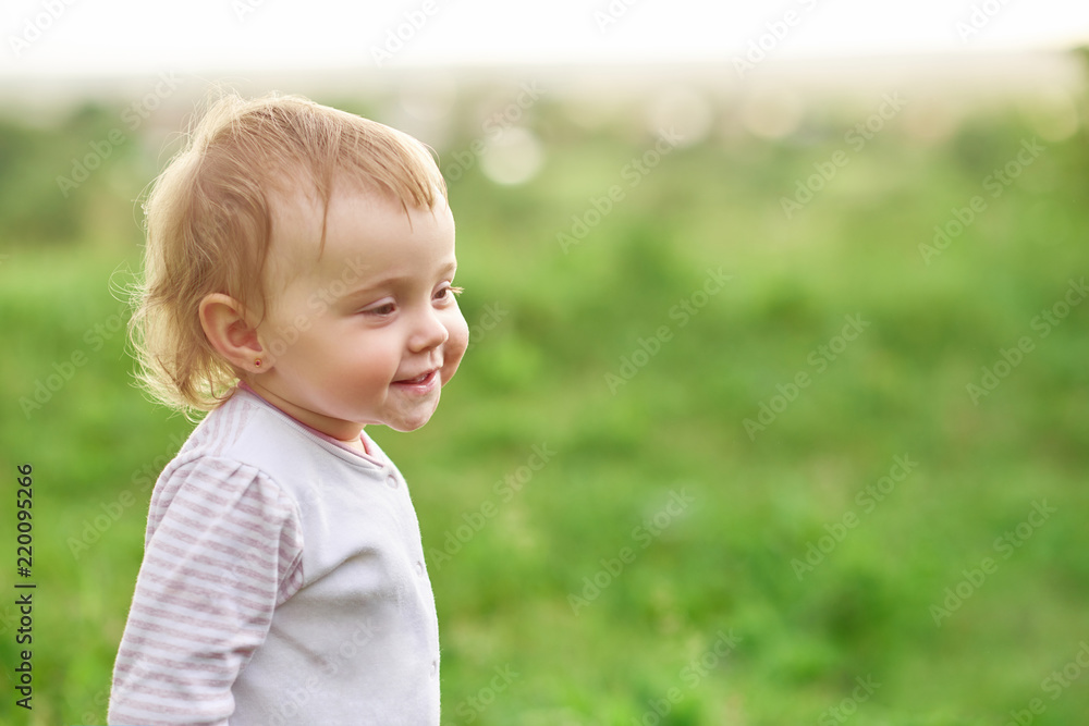 Portrait of smiling little child walking on green field. Portrait of smiling little child walking on green field.