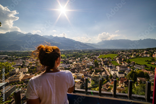Female tourist admiring view of Vaduz, Liechtenstein. Vaduz is the capital of Liechtenstein and also the seat of the national parliament.