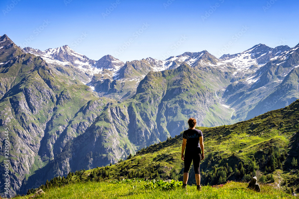 Female traveler admiring views of Swiss Alps in Val de Bagnes area, Switzerland.