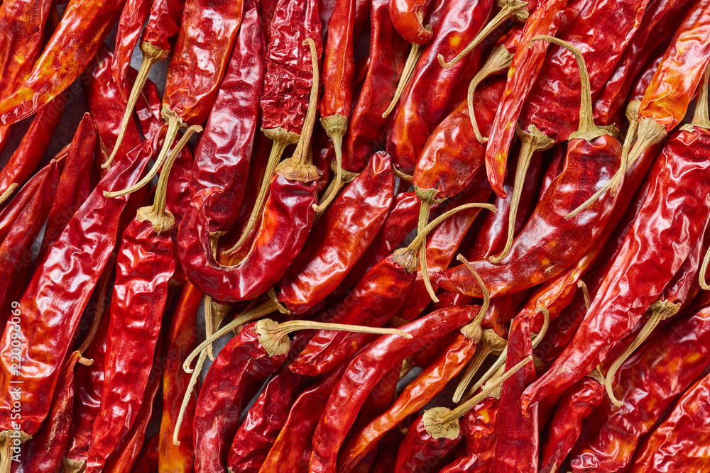 full frame of red dried chili peppers as background