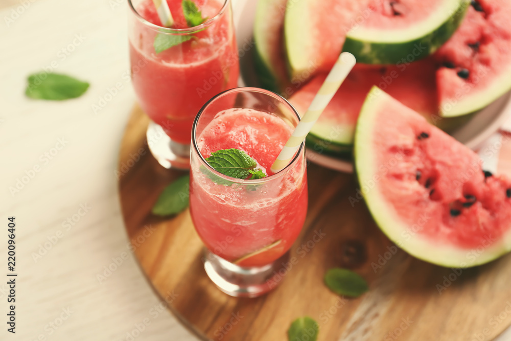 Glasses with fresh smoothie and watermelon slices on wooden board Glasses with fresh smoothie and watermelon slices on wooden board
