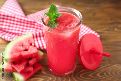 Glass with fresh watermelon smoothie on wooden table