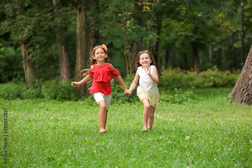 Cute little girls running in park on summer day