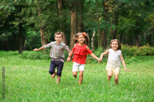 Cute little children running in park on summer day