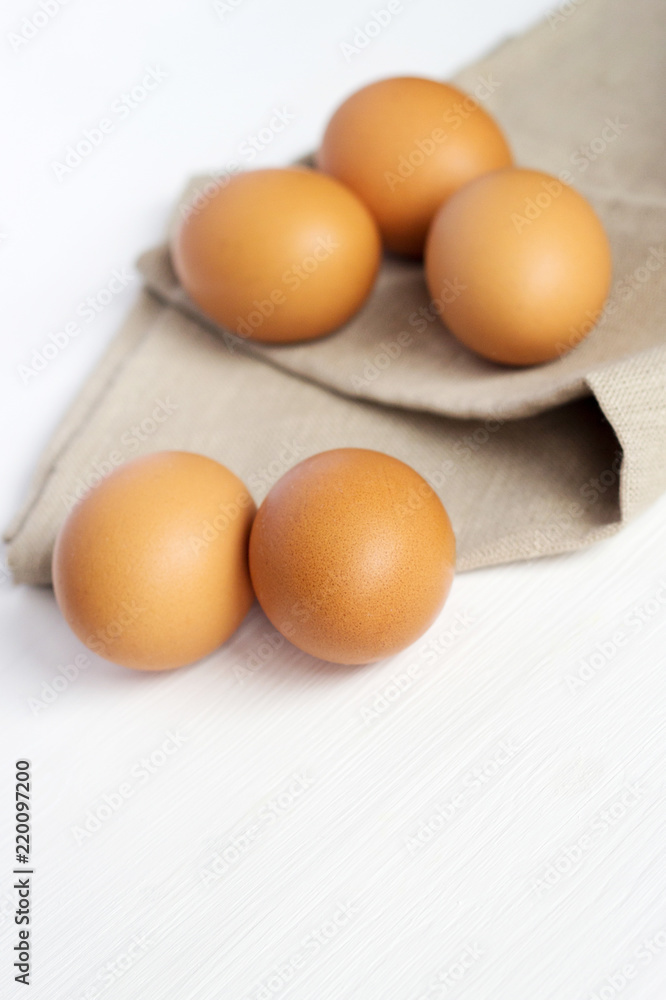 Brown chicken eggs on burlap on a white background Brown chicken eggs on burlap on a white background