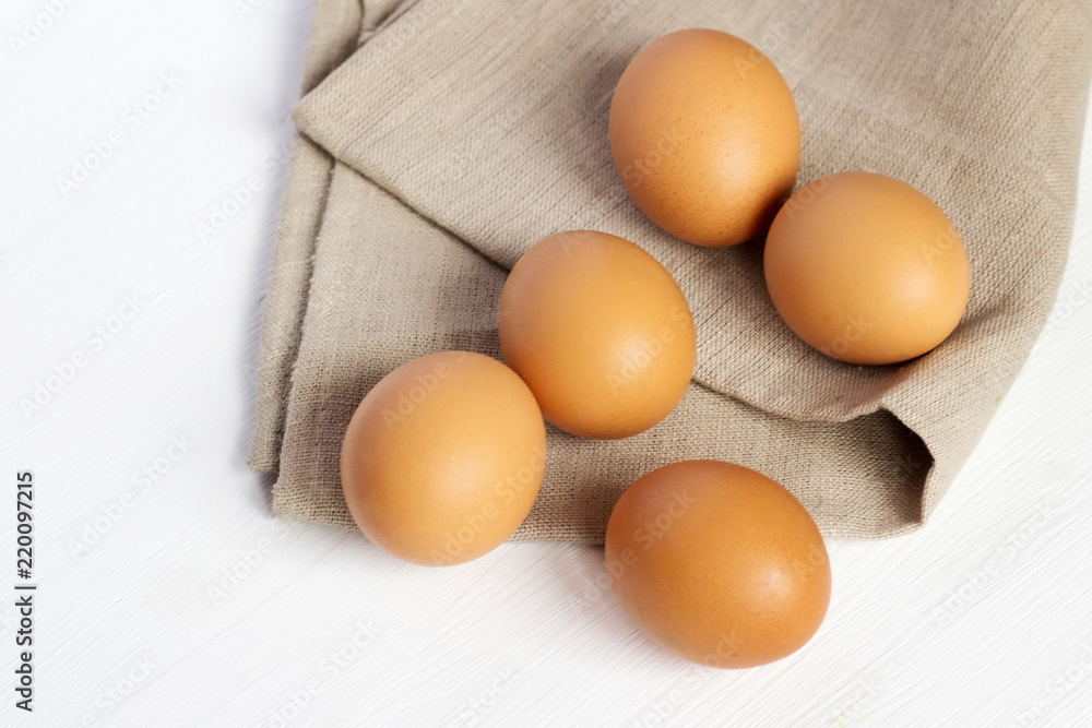 Brown chicken eggs on burlap on a white background Brown chicken eggs on burlap on a white background