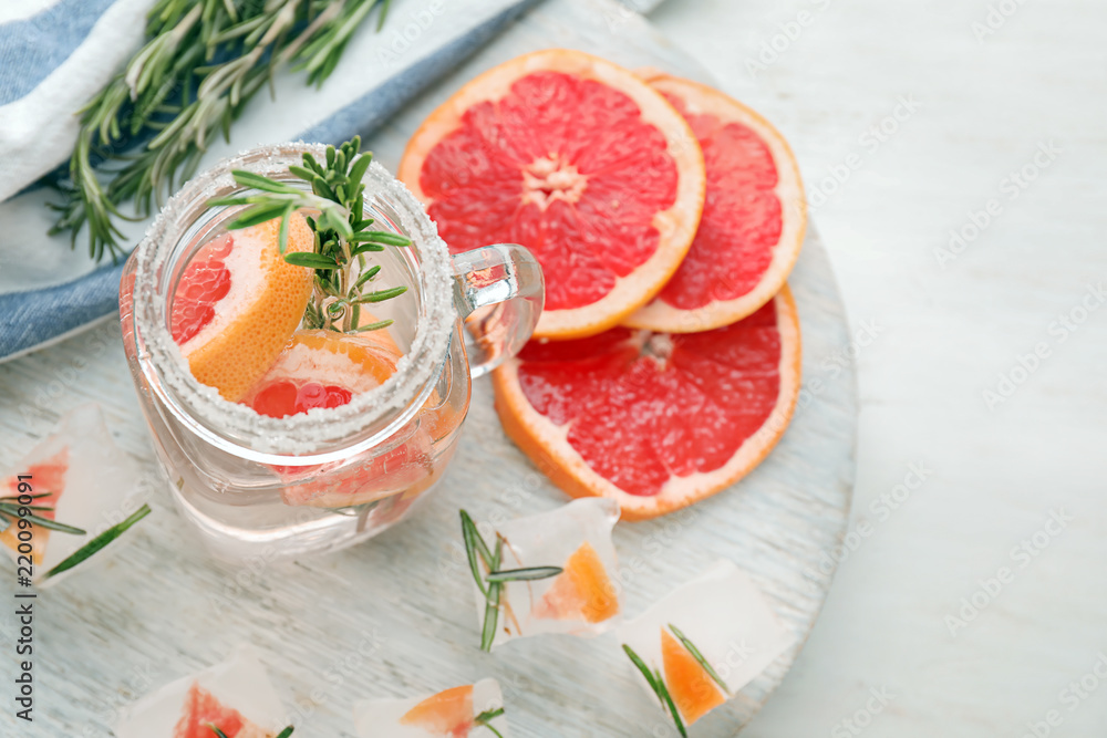 Fresh grapefruit cocktail with rosemary in mason jar on wooden board Fresh grapefruit cocktail with rosemary in mason jar on wooden board