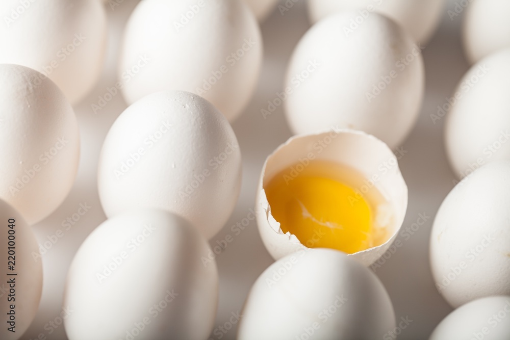 Single Cracked Egg Amongst Many Intact Eggs Close-up Single Cracked Egg Amongst Many Intact Eggs Close-up