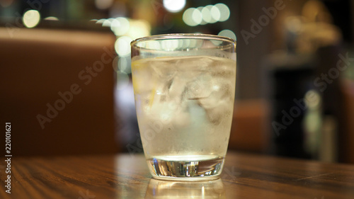 Clean water with ice in the glass on the table. Water in a glass, selective focus.