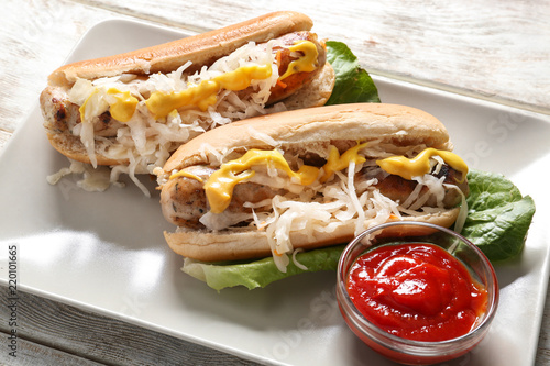 Canvas Print Tasty hot dogs with sauerkraut and sauce on plate