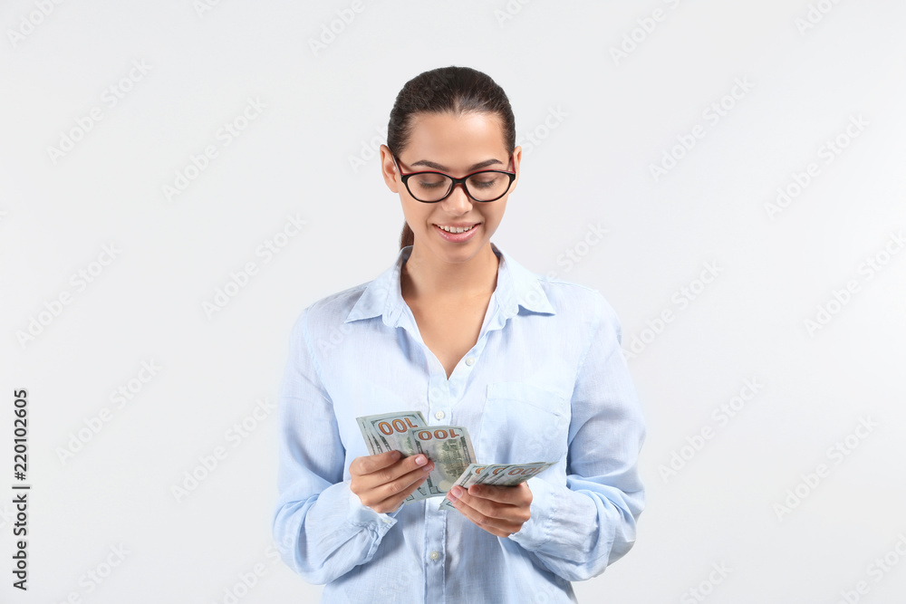 Happy young woman with dollar banknotes on light background Happy young woman with dollar banknotes on light background