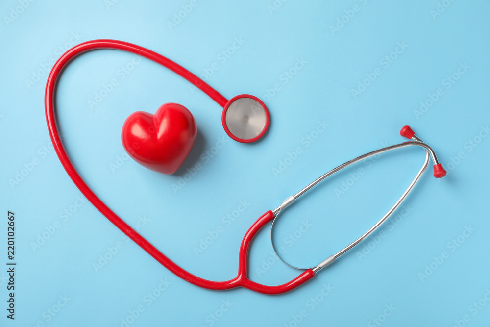Medical stethoscope and red heart on color background. Cardiology concept Medical stethoscope and red heart on color background. Cardiology concept