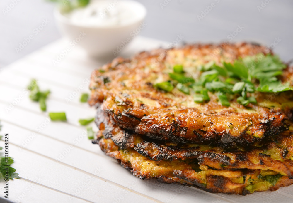 Zucchini pancakes on wooden board, closeup Zucchini pancakes on wooden board, closeup