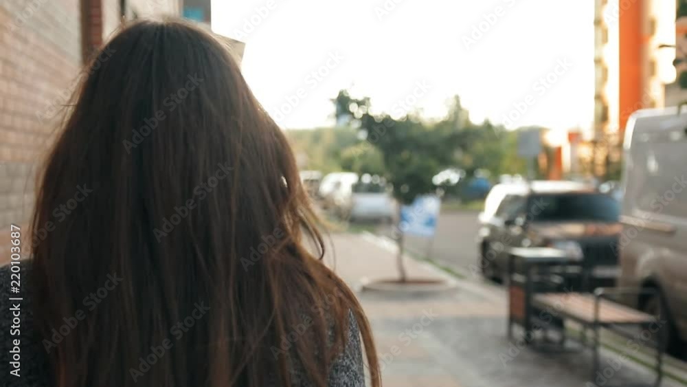 Portrait of a young sexy woman walking around the city, hair fluttering in the wind. Slow motion shot. Portrait of a young sexy woman walking around the city, hair fluttering in the wind. Slow motion shot.