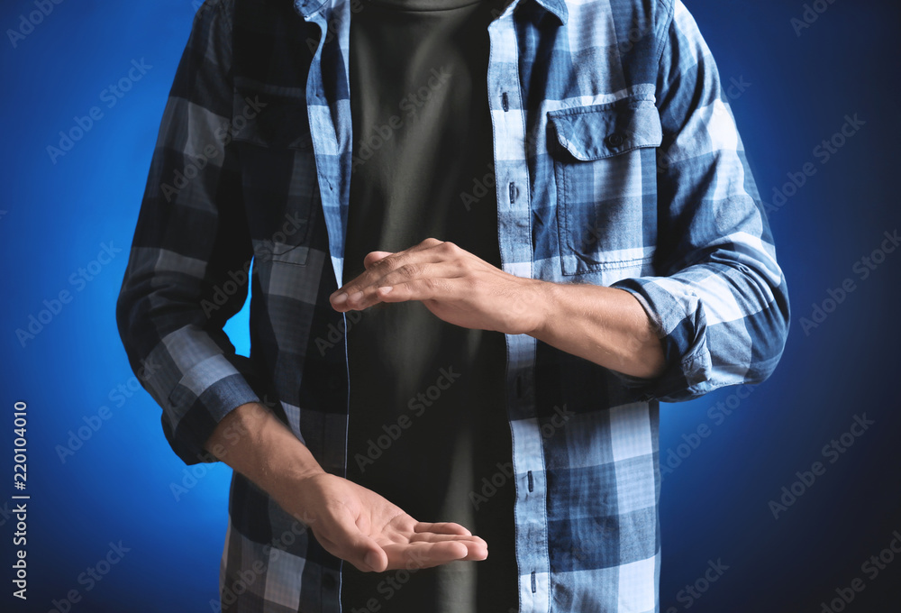 Young man holding something on color background