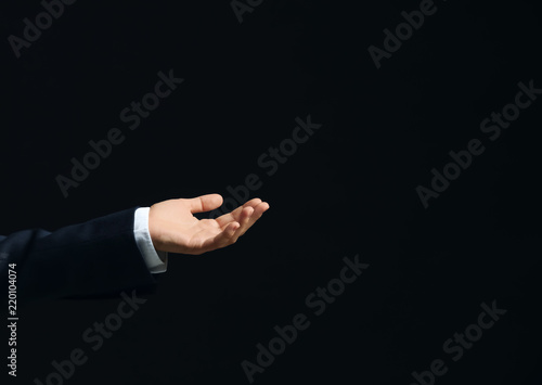 Businesswoman holding something on dark background
