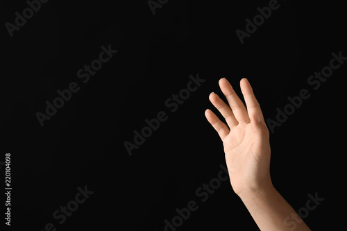 Young woman using virtual screen on dark background