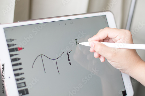 Hand of student writing math formula on ipad with apple pen with drawing application