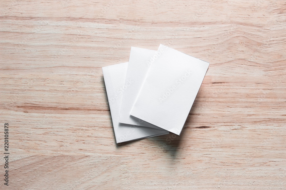 Blank portrait mock-up paper. brochure magazine isolated on brown wooden table, changeable background / white paper isolated on wood Blank portrait mock-up paper. brochure magazine isolated on brown wooden table, changeable background / white paper isolated on wood