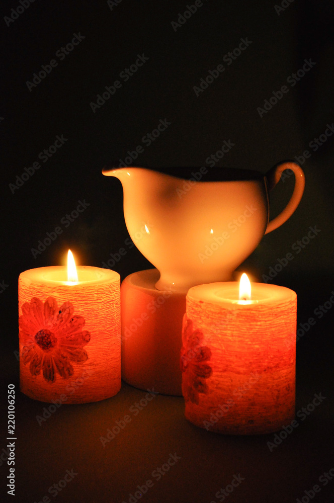 Two burning candles and a porcelain kettle Two burning candles and a porcelain kettle