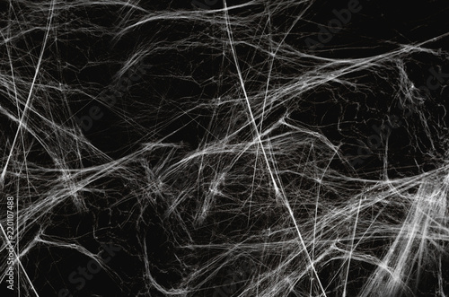 halloween, decoration and horror concept - artificial spider web over black background