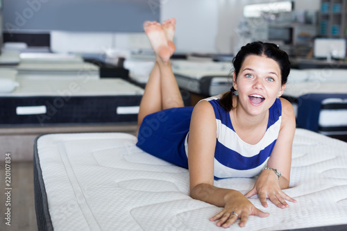 Happy woman lying on comfortable mattress