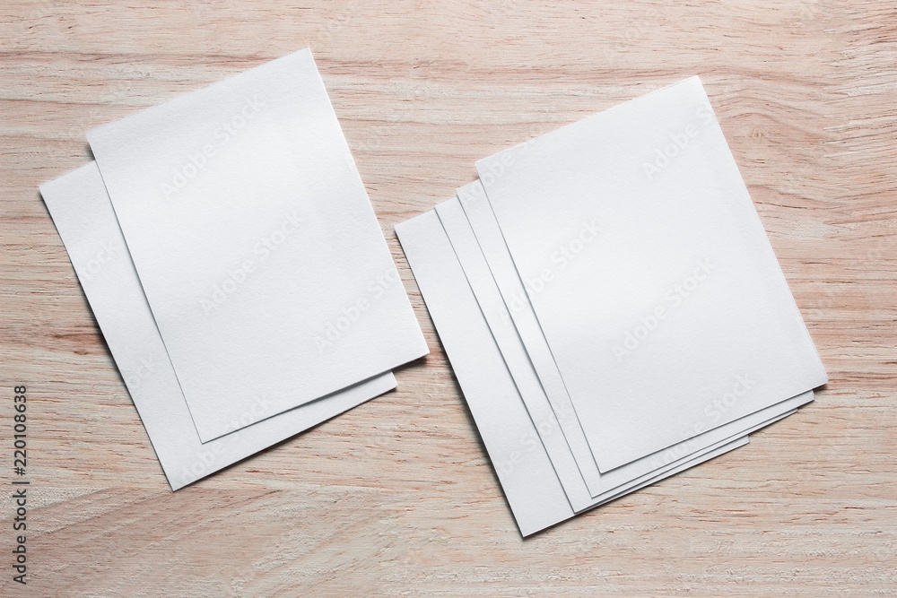 Blank portrait mock-up paper. brochure magazine isolated on brown wooden table, changeable background / white paper isolated on wood Blank portrait mock-up paper. brochure magazine isolated on brown wooden table, changeable background / white paper isolated on wood