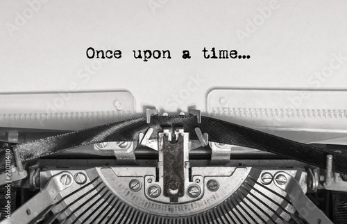 once upon a time... the text is typed on a vintage typewriter with black ink on old paper, close-up