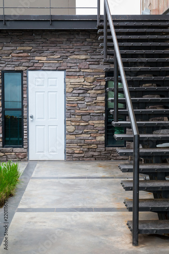 Wall stone front yard and White door with Second floor staircase.