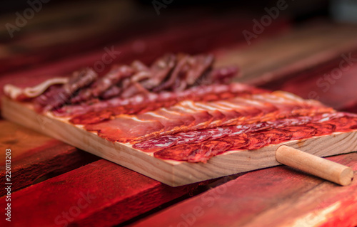 Gourmet plate of serrano ham jamon and sausage in Spain. Wooden plate