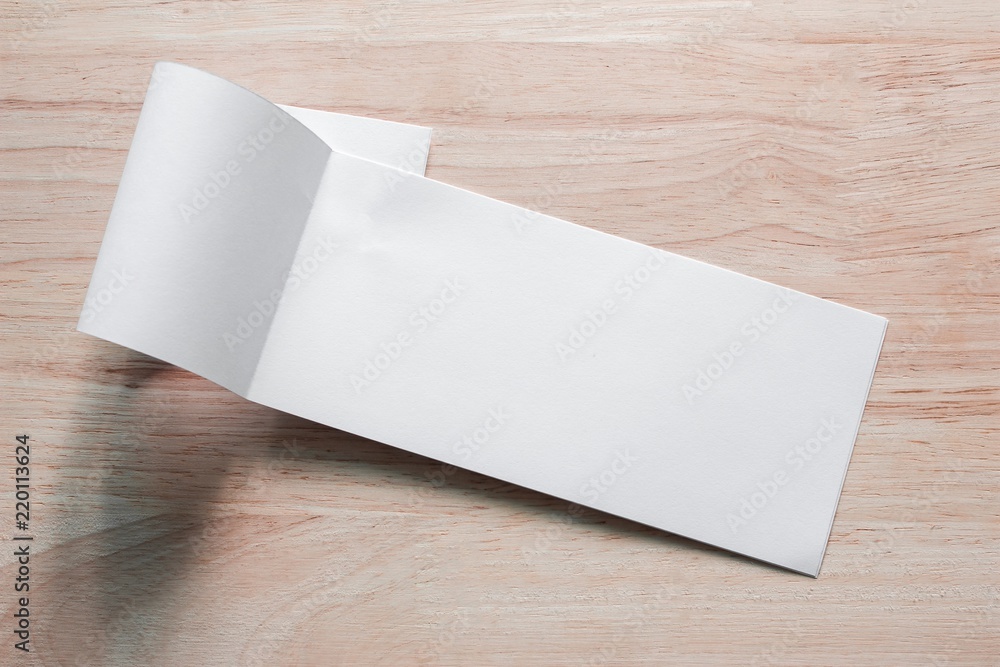 Blank portrait mock-up paper. brochure magazine isolated on brown wooden table, changeable background / white paper isolated on wood Blank portrait mock-up paper. brochure magazine isolated on brown wooden table, changeable background / white paper isolated on wood