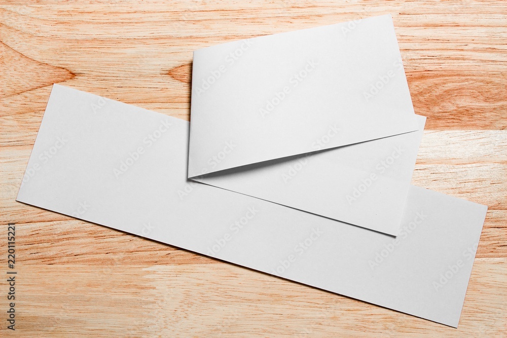 Blank portrait mock-up paper. brochure magazine isolated on brown wooden table, changeable background / white paper isolated on wood Blank portrait mock-up paper. brochure magazine isolated on brown wooden table, changeable background / white paper isolated on wood