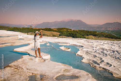The enchanting pools of Pamukkale in Turkey. Pamukkale contains hot springs and travertines, terraces of carbonate minerals left by the flowing water. The site is a UNESCO World Heritage Site. photo