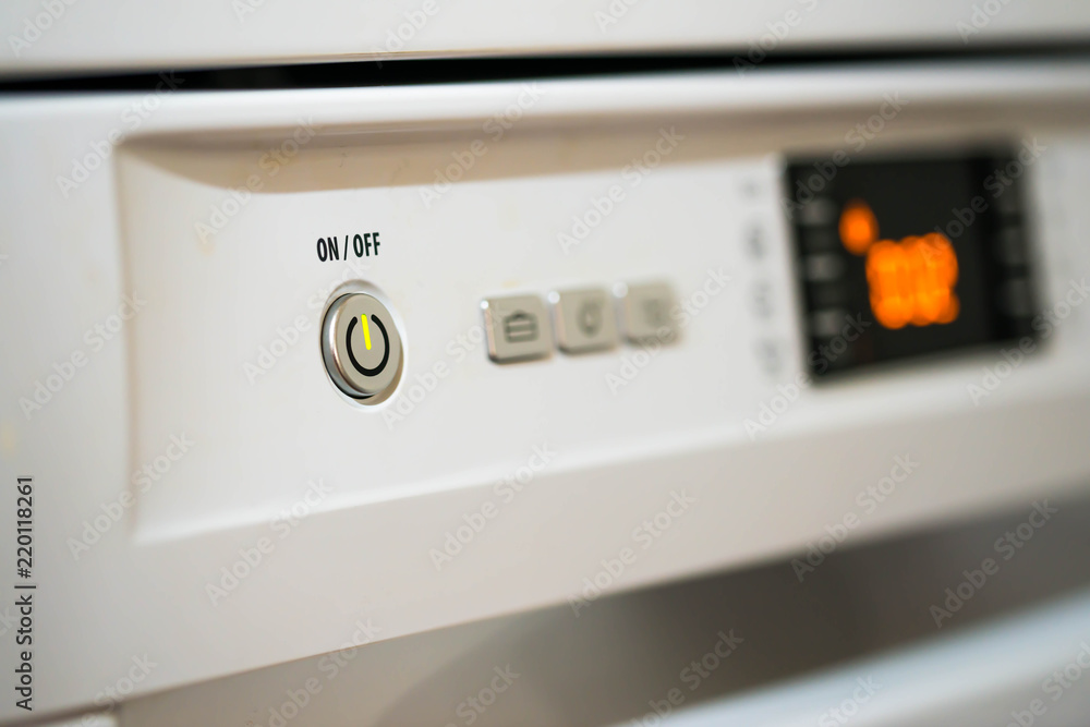 Dishwasher in function ,on off switch on focus, close up macro shot. Dishwasher in function ,on off switch on focus, close up macro shot.