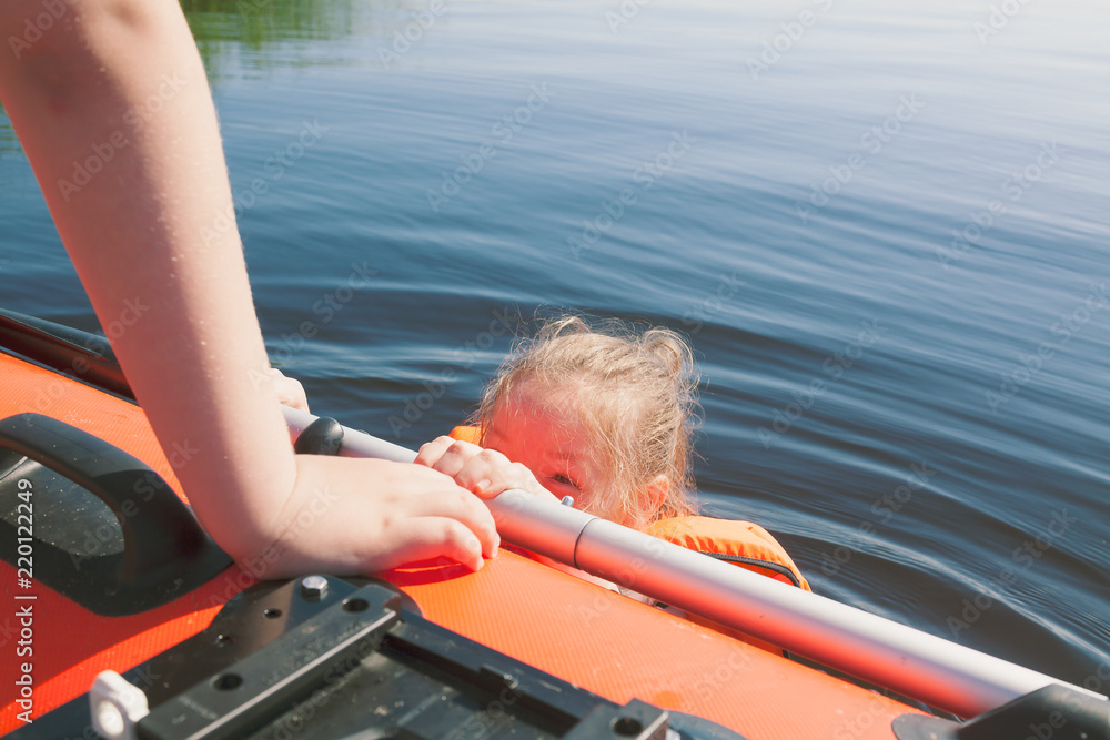 Fototapeta premium Girl is swimming in the lake near the boat