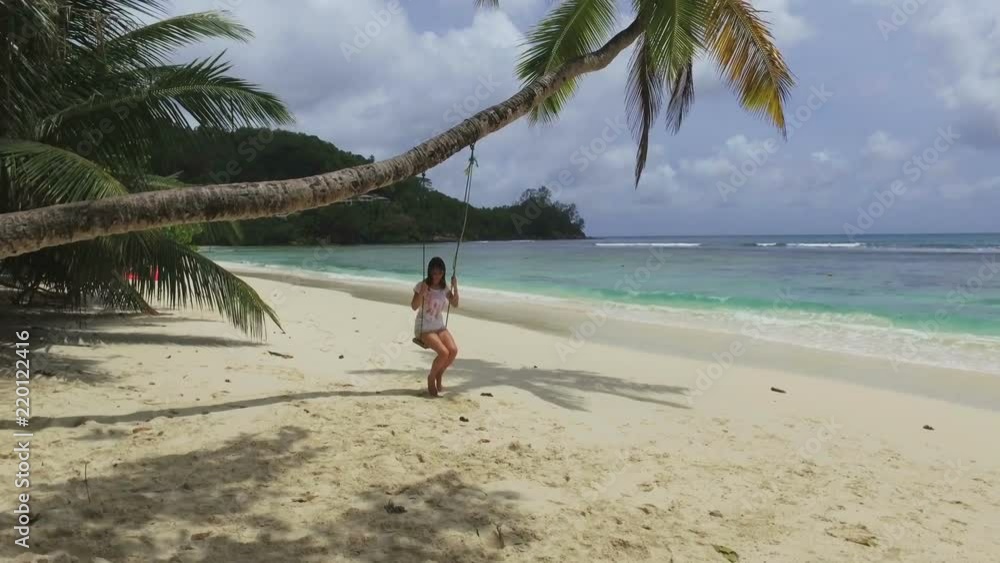 A Girl Swinging On A Palm Tree, Baie Lazare Beach, Seychelles A Girl Swinging On A Palm Tree, Baie Lazare Beach, Seychelles