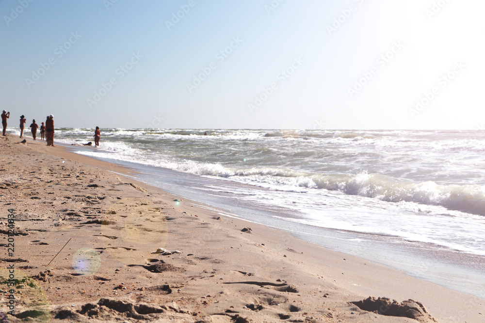 Amazing beach sunset with endless horizon and lonely figures in the distance, and incredible foamy waves Amazing beach sunset with endless horizon and lonely figures in the distance, and incredible foamy waves