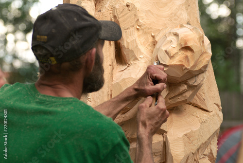 Woodcarver make his sculpture by the chisel. Photo from a carpenter's contest. Selective focus.