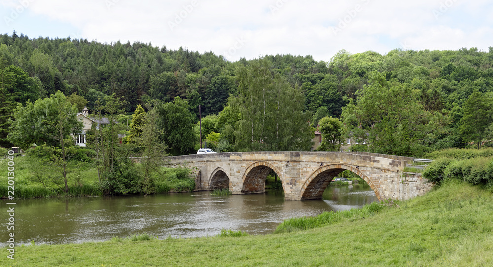 Old arched stone bridge across the River Derwent at Kirkham in North Yorkshire, England