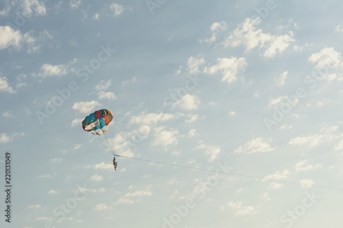 Round parachute against the sunset sky with clouds in an unusual color scheme. Multi-color process.