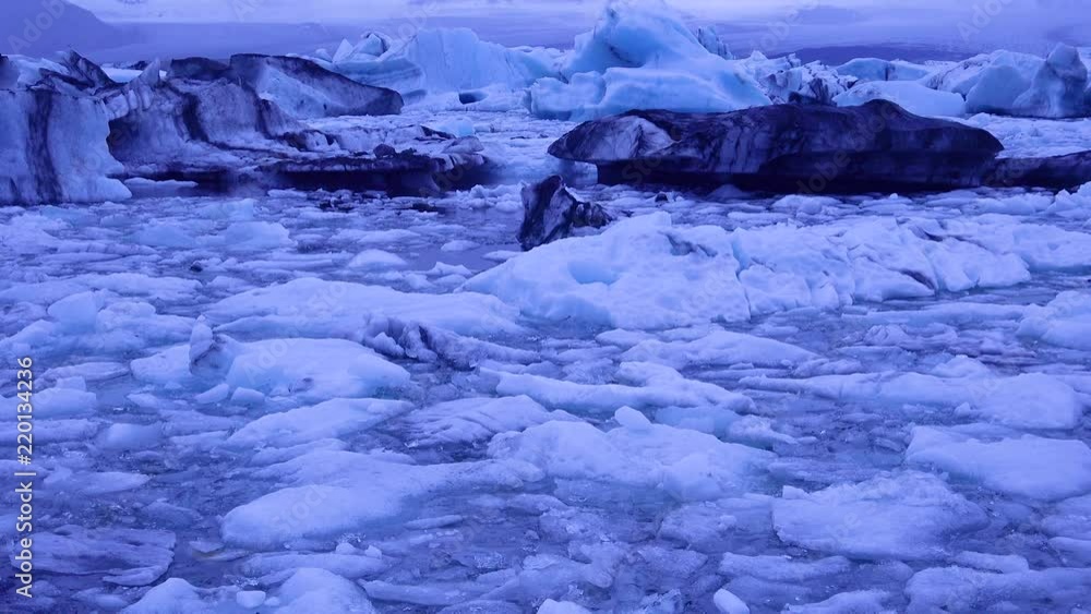 Tilt up to icebergs sitting in a glacial bay, suggesting global warming in the Arctic at Jokulsarlon glacier lagoon, Iceland, night. Tilt up to icebergs sitting in a glacial bay, suggesting global warming in the Arctic at Jokulsarlon glacier lagoon, Iceland, night.