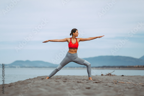 Fototapeta Naklejka Na Ścianę i Meble -  Young woman practicing yoga on the beach