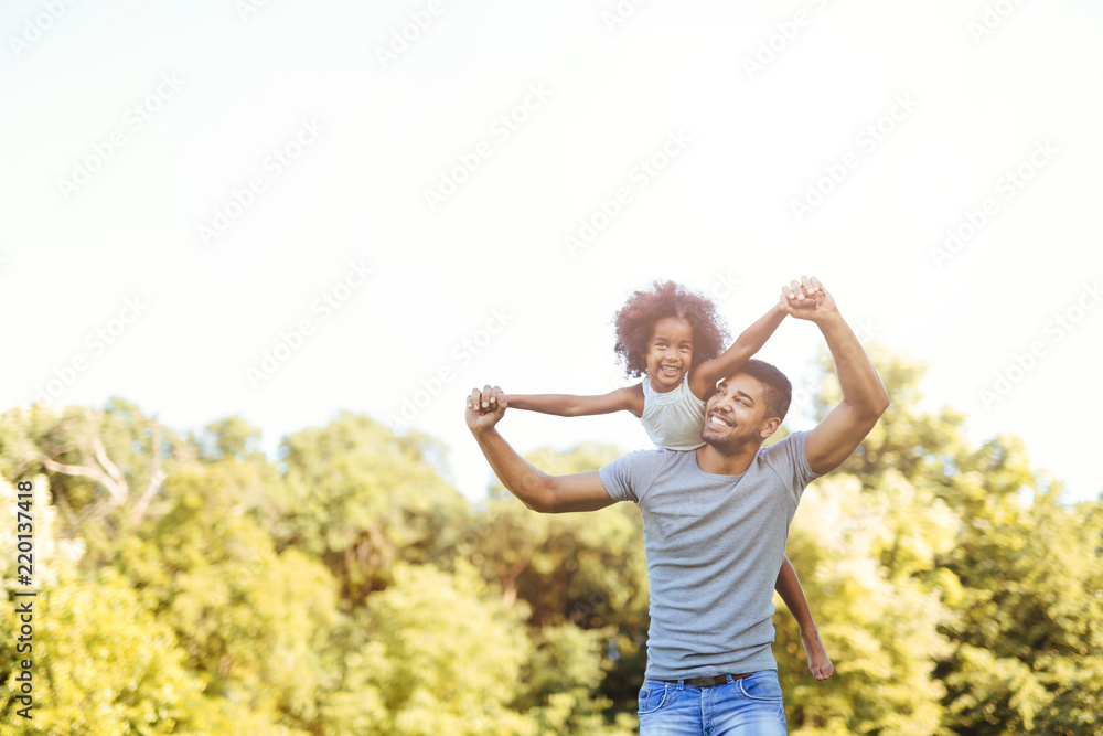 Portrait of young father carrying his daughter on his back Portrait of young father carrying his daughter on his back