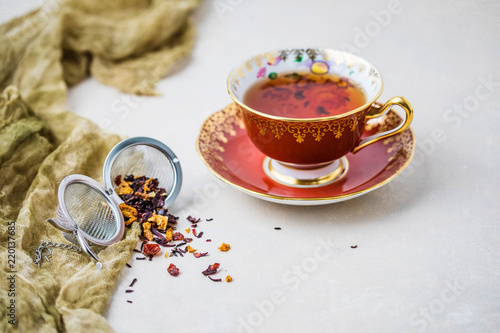Royal Albert Fine Bone China Red Tea Cup and Saucer with Herbal Tea and Tea Infuser on Gray Background
