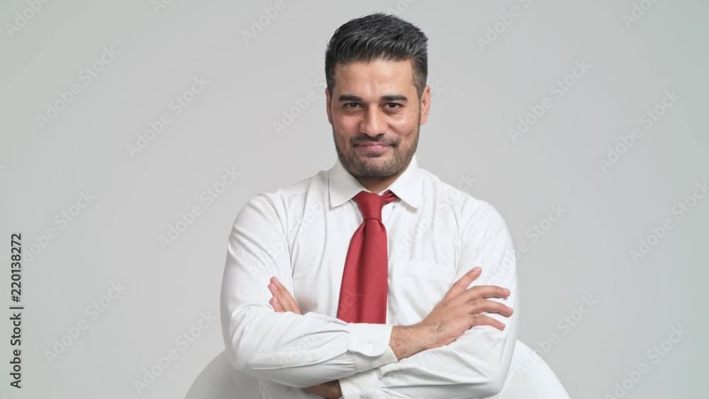 Confident businessman portrait in white background. Young indian man in white shirt and red tie pose confident smile to camera. Young businessman concept. Confident businessman portrait in white background. Young indian man in white shirt and red tie pose confident smile to camera. Young businessman concept.