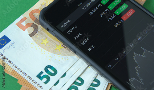 European Euro banknotes and smartphone, mobile trading.